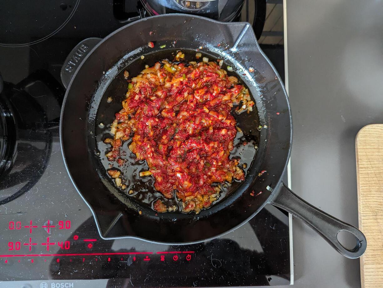 Onion and tomato paste in a pan